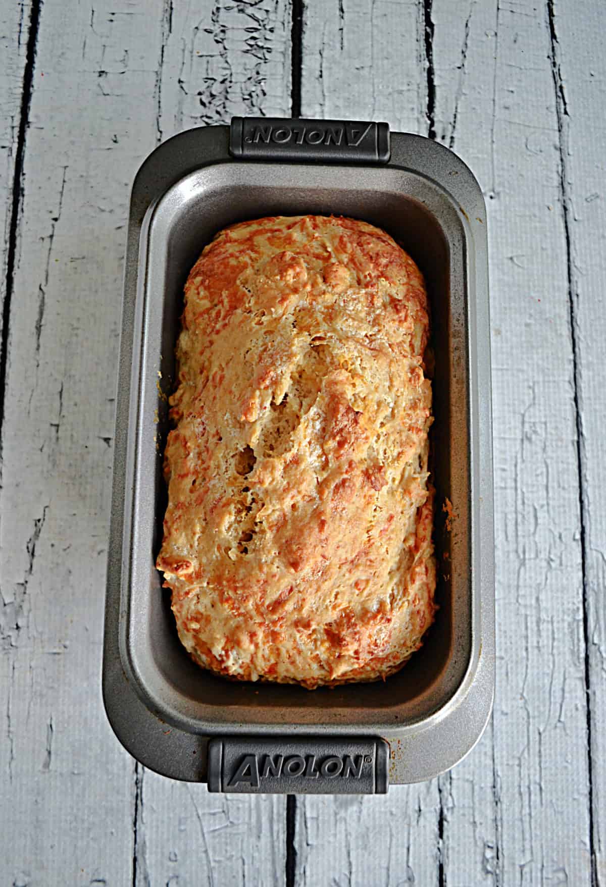 A loaf of Cheddar Beer Bread in a loaf pan.