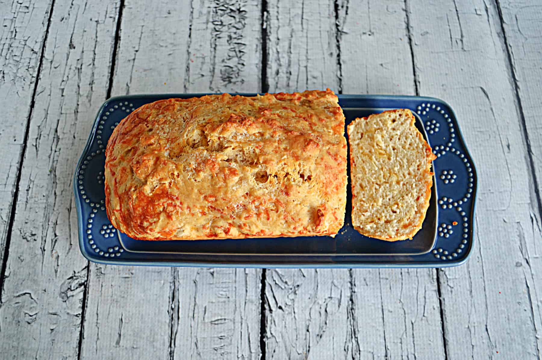 A loaf of Cheddar Beer Bread with a slice cut off.