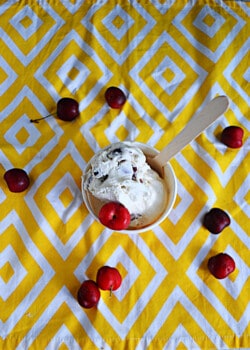 A top view of a cup of cherry vanilla ice cream with cherries all around.