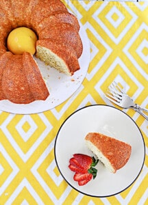 A slice of lemon cake with the whole cake next to it.