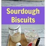 Pin Image: A plate lined with four biscuits on a white wooden backdrop, text overlay, a cutting board topped with a sourdough starteer, baking soda, salt, butter, and flour.