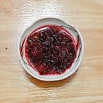 A small bowl filled with chunky cranberry sauce.
