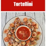 Pin Image: Text title, a plate of fried tortellini with a bowl of sauce in the middle.