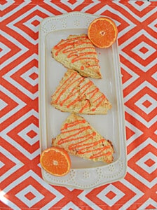 A platter with three scones drizzled with tangerine glaze.