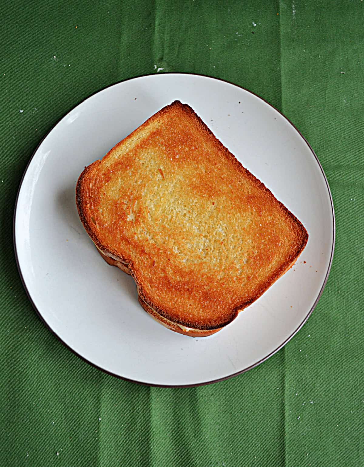 A plate with a grilled cheese sandwich on it.