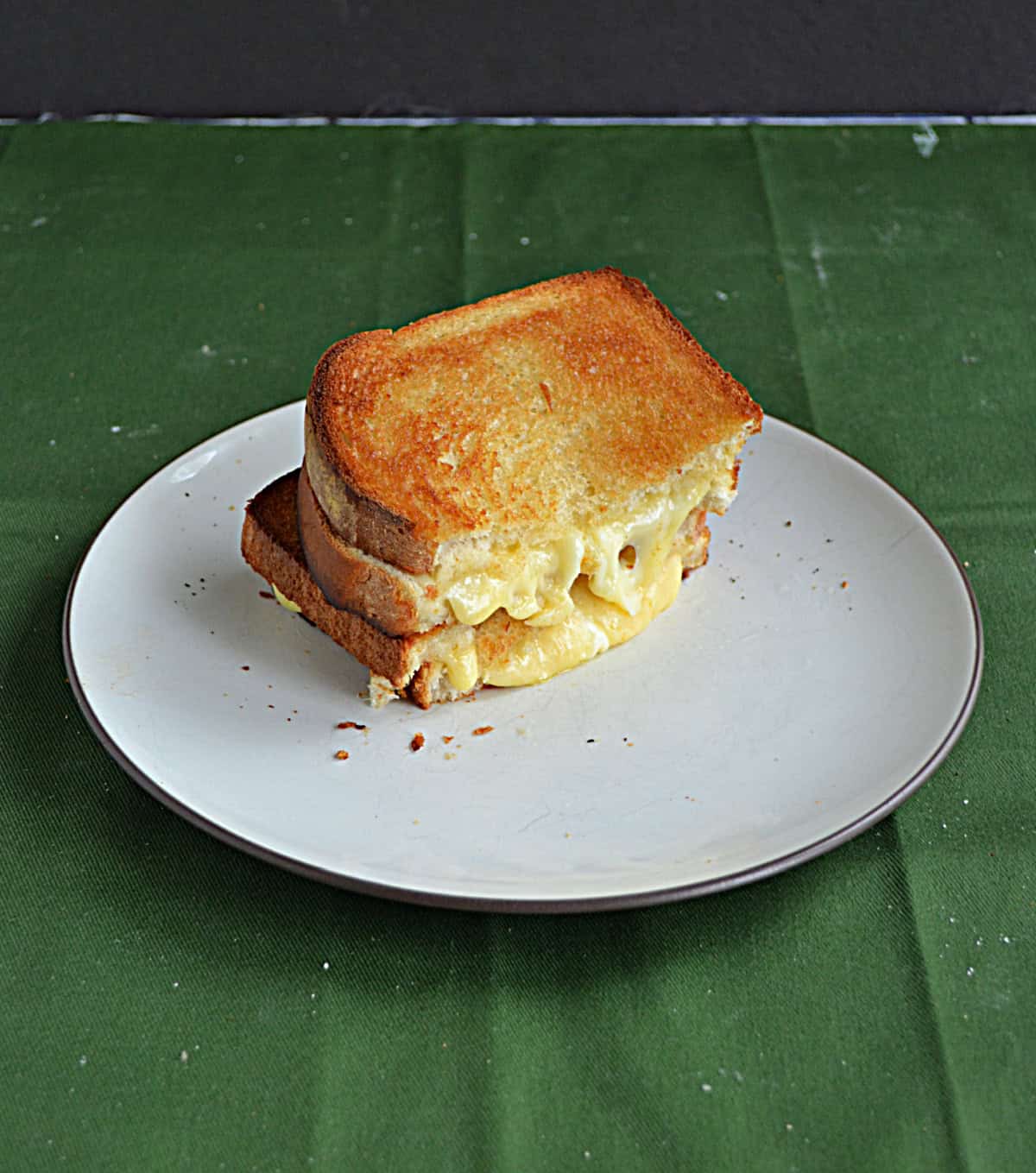 A plate with a grilled cheese sandwich cut in half and stacked.