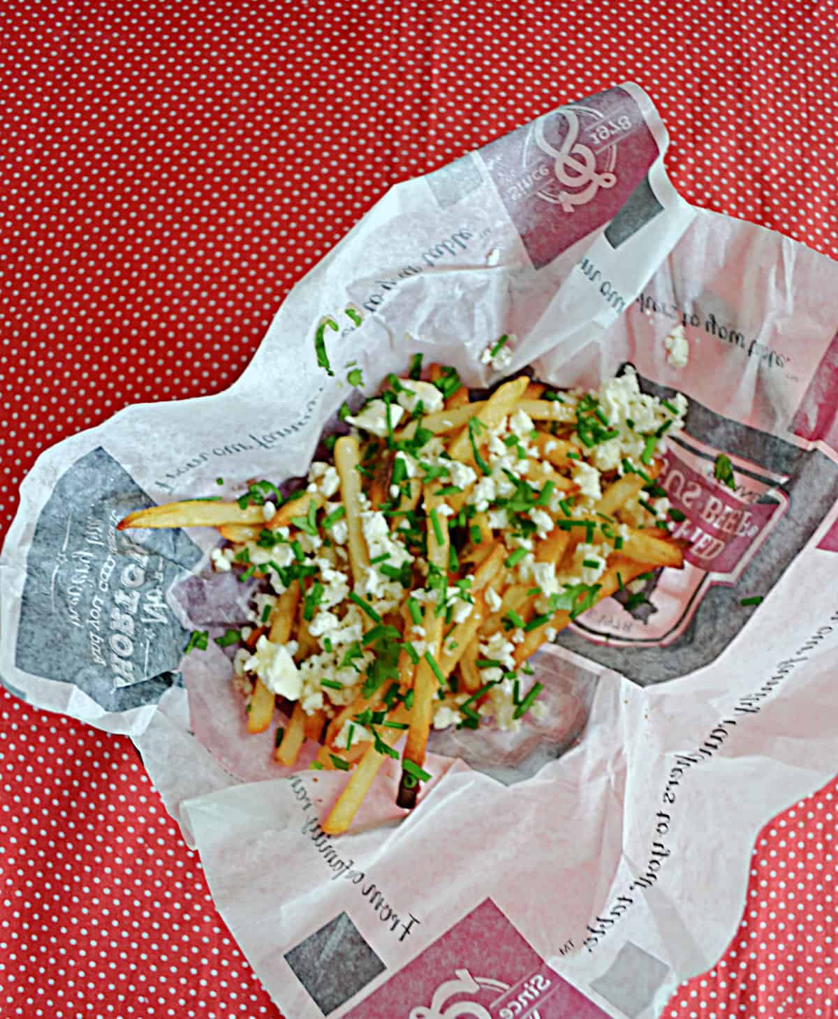 A basket of french fries with hot honey and feta on top.