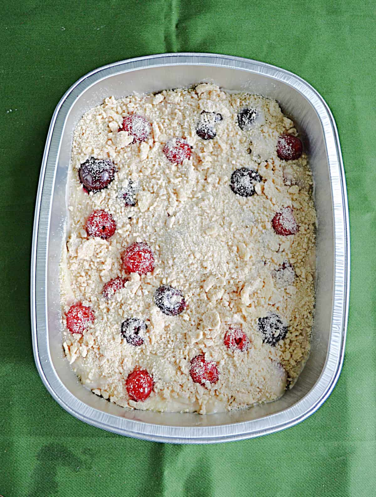 A pan of cherry coffee cake with crumble topping waiting to be baked.