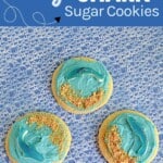 Pin Image: Text title, three sugar cookies with blue frosting, graham cracker crumb sand, and blue shark gummies.