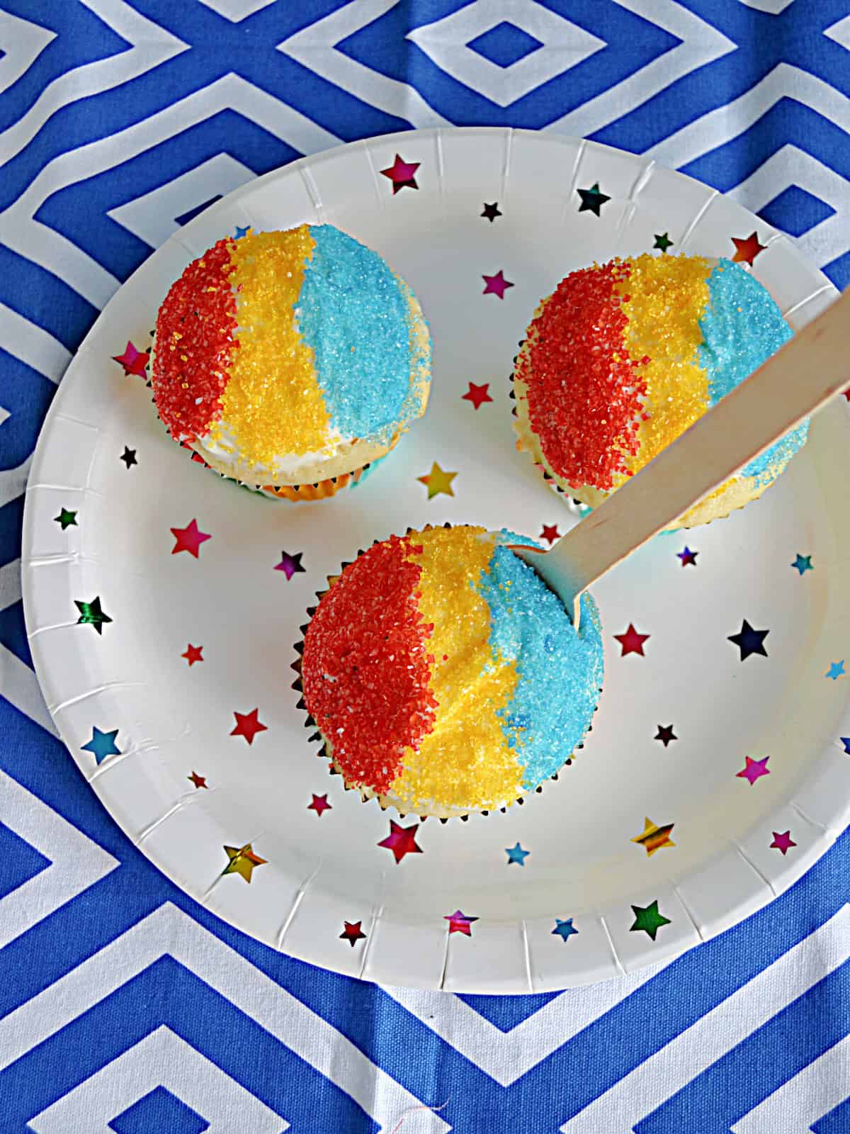 A plate with three snow cone cupcakes on it.