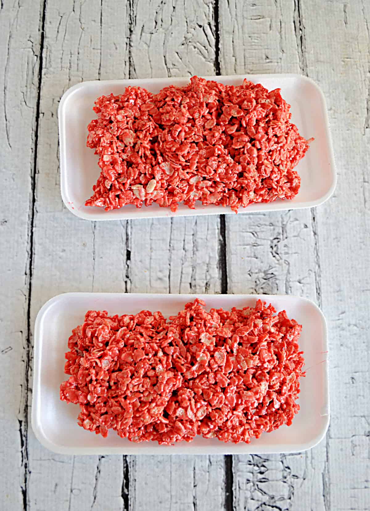 Two foam trays filled with red rice krispies treats.