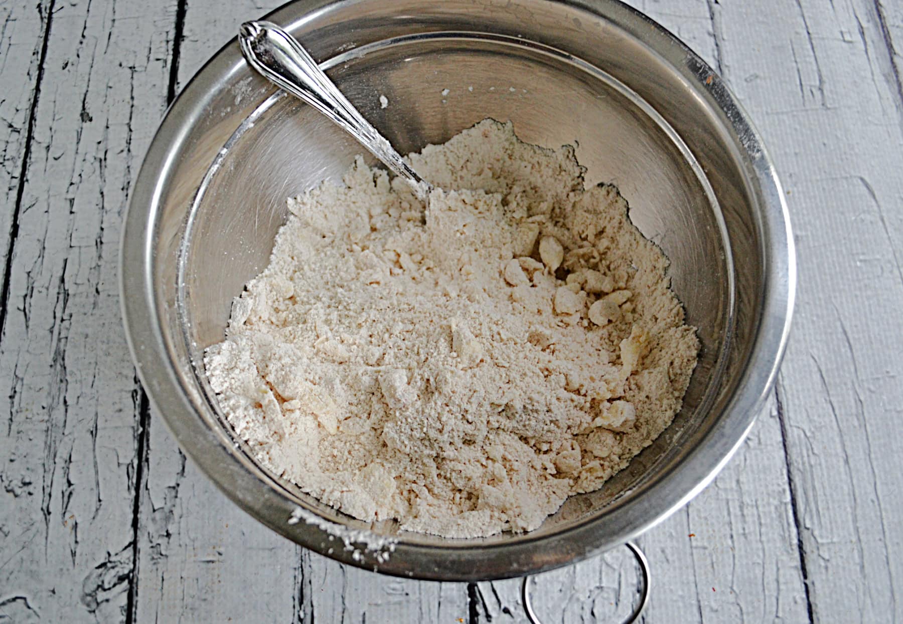 A mixing bowl with flour and butter in it.