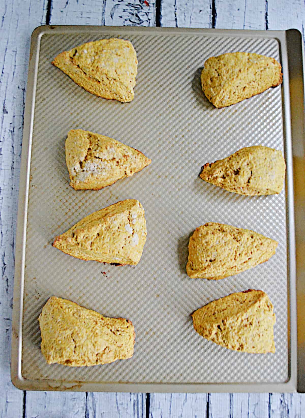 A baking sheet with baked scones on it.